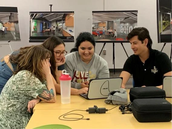 students gathered around a laptop