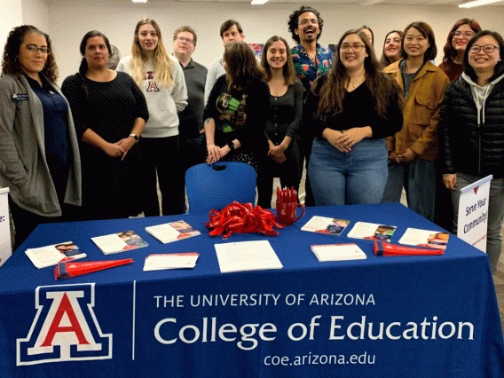 college of ed students standing behind a table